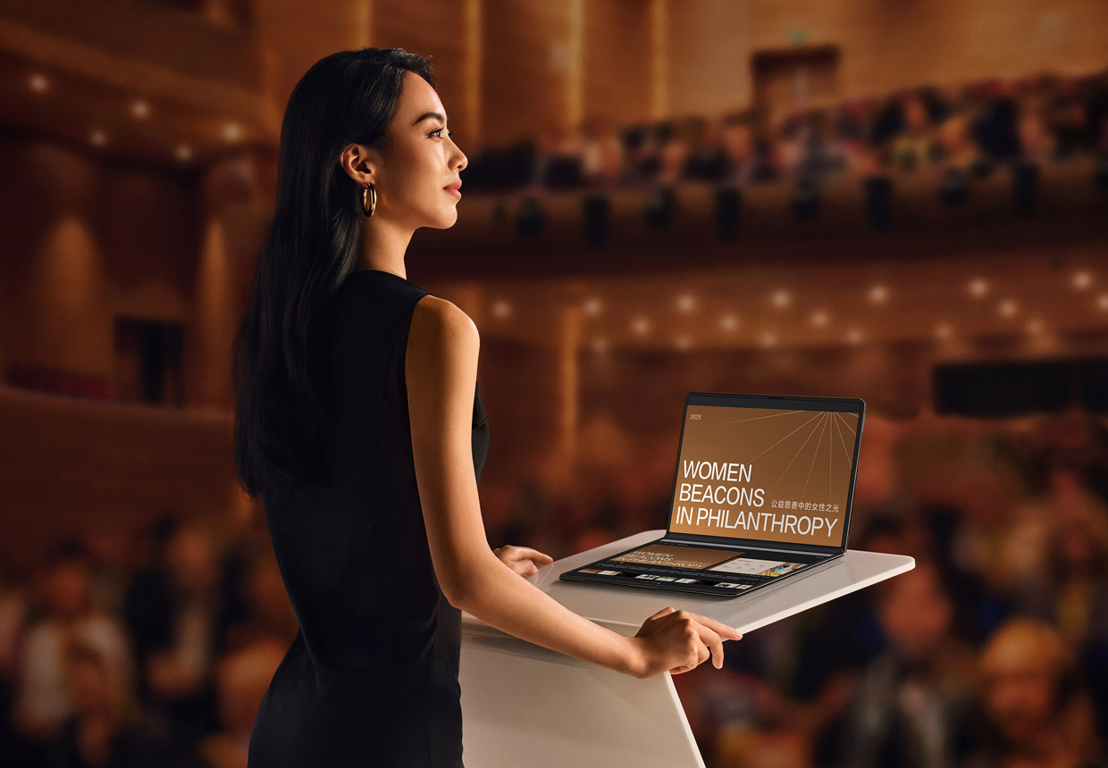 女人使用折叠态的 HUAWEI MateBook Fold 企业版进行演讲，电脑上屏显示演示文档，下屏显示题词和预览后续的幻灯片内容