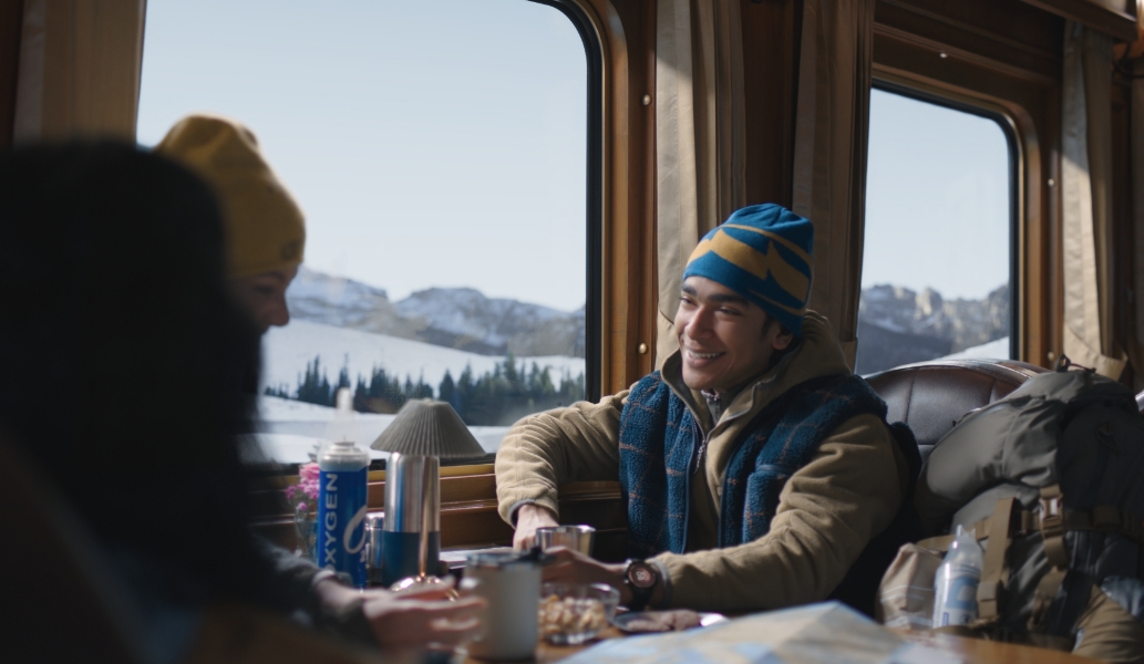 一对男女坐在行驶在高原上的火车中，通过手腕上佩戴的华为擎云 H7556 测量实时血氧