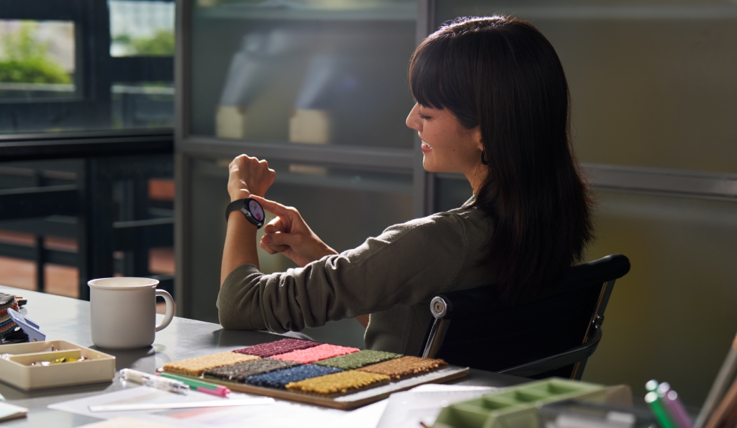 一位女性用户坐在座位上，通过手腕上佩戴的华为擎云 H7556 体验一些趣味的交互小游戏