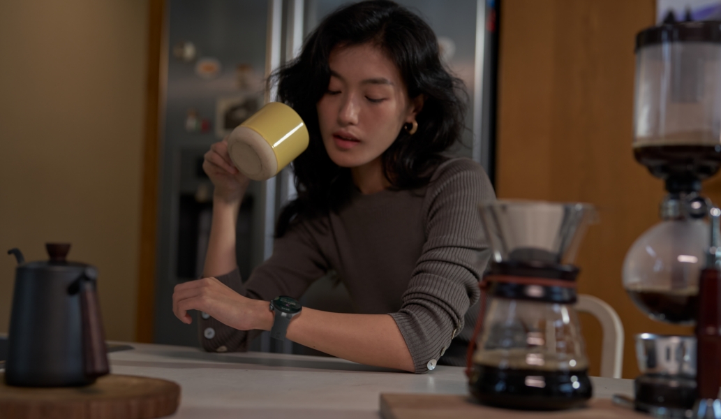 一位女性用户低头看向手腕上佩戴的华为擎云 H7556， 展示了手表的健康分析的功能